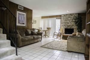 A paneled room with couches, bookcases, table and chairs