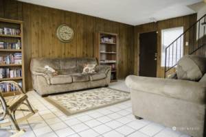 A paneled room with couches, bookcases and chairs